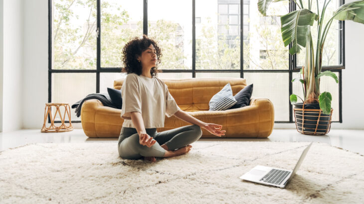 mulher meditando no chão da sala