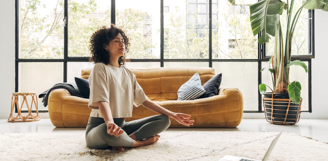 mulher meditando no chão da sala