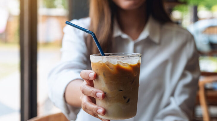 mulher segurando um copo de café gelado em um restaurante