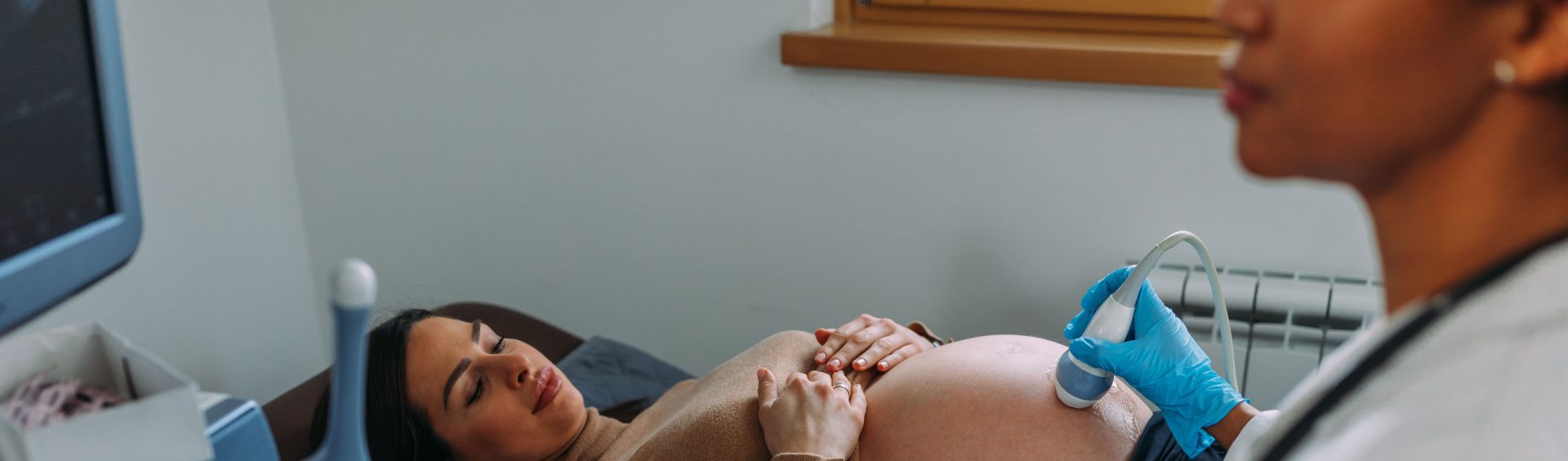 médica realizando o ultrassom em uma grávida na clínica