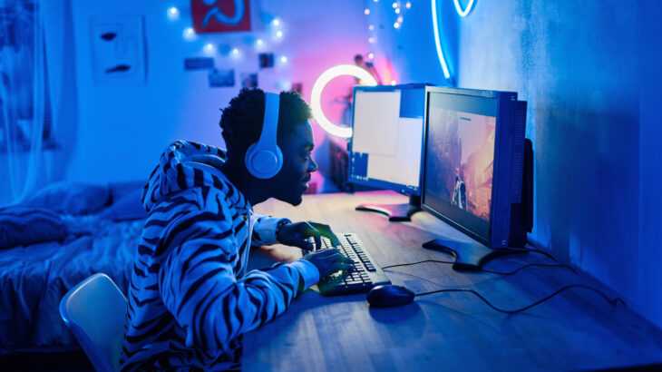 jovem adulto jogando videogame no computador em seu quarto