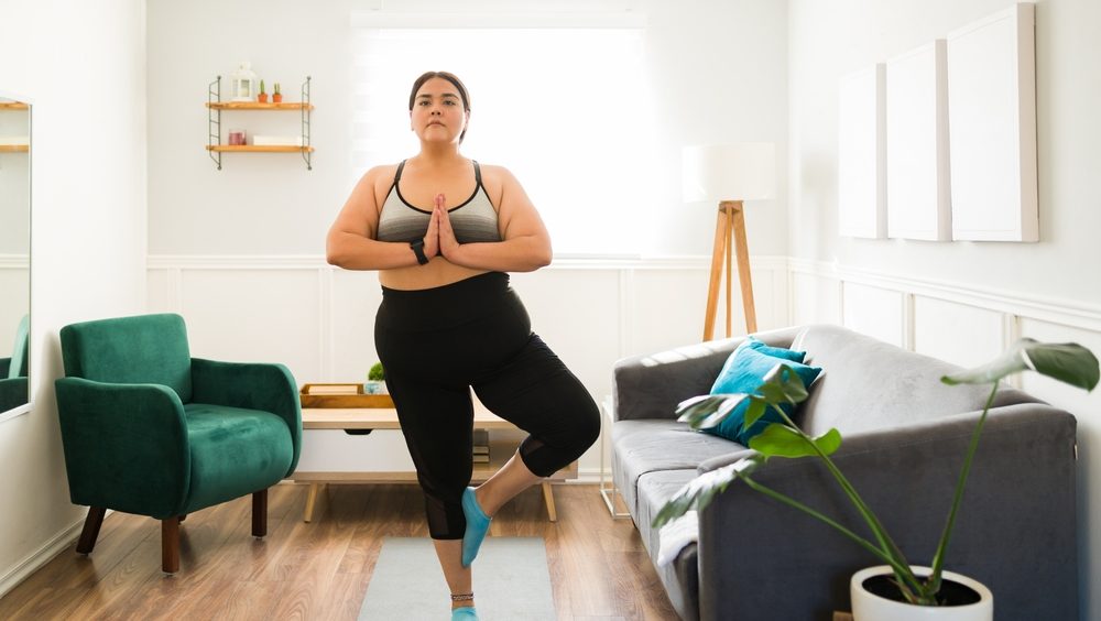 Mulher praticando yoga em casa