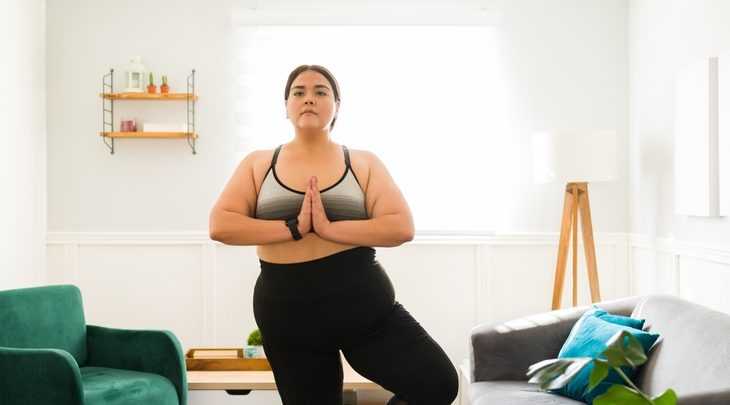 Mulher praticando yoga em casa