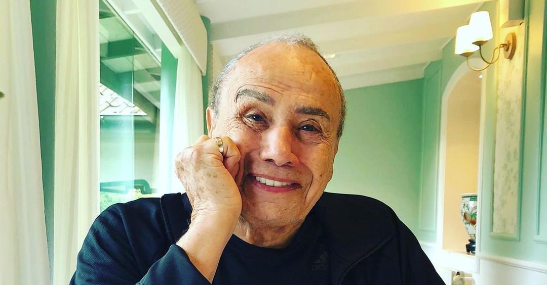 ator Stenio Garcia com um dos braços apoiado em uma mesa e a mão no rosto