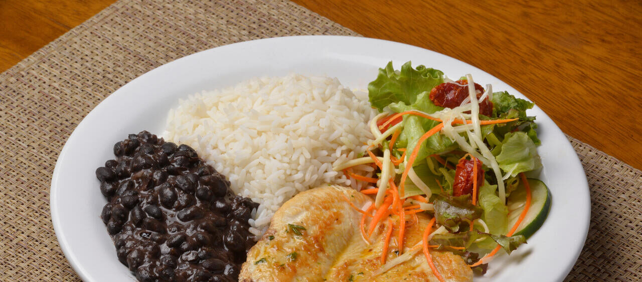 prato com uma refeição típica brasileira: arroz, feijão, filé de frango e salada