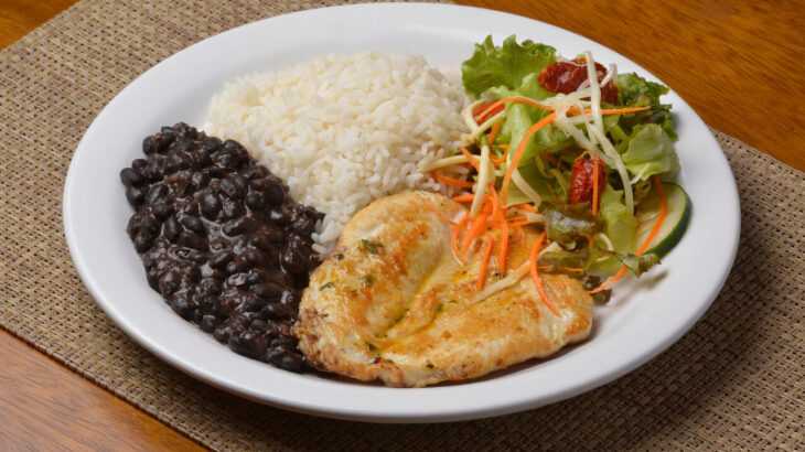 prato com uma refeição típica brasileira: arroz, feijão, filé de frango e salada