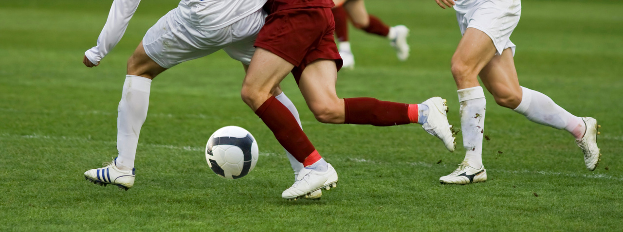 pernas de jogadores de futebol em uma partida