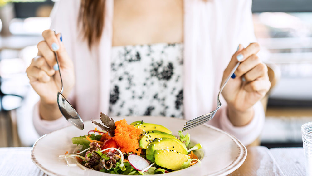 mulher comendo refeição saudável
