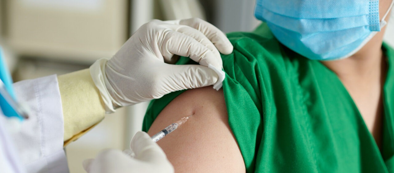 profissional de saúde aplicando vacina no braço de uma pessoa