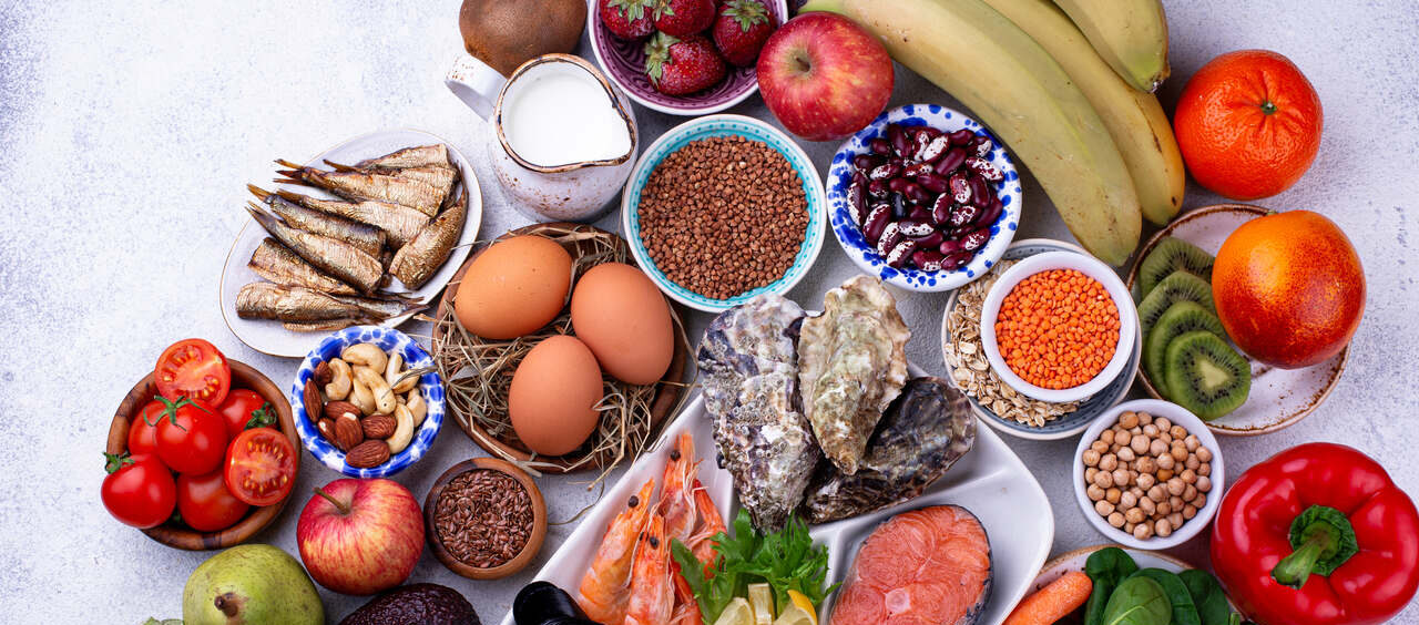 foto com diferentes alimentos naturais, como frutas, verduras e proteínas saudáveis