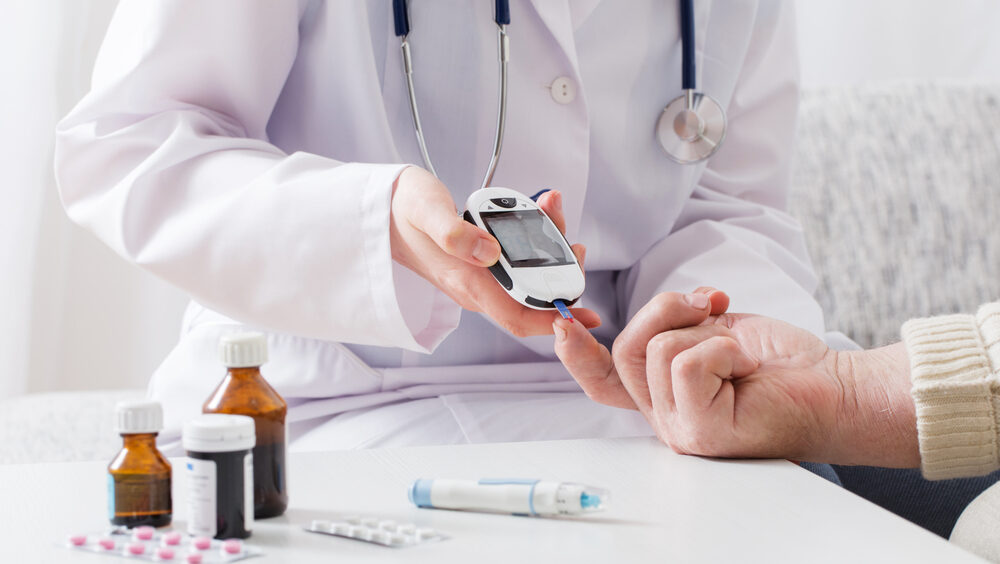 médico medindo a glicemia de paciente