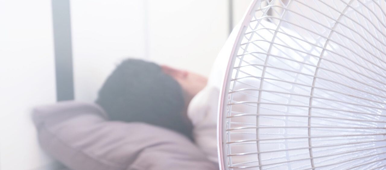 pessoa dormindo e um ventilador ao lado