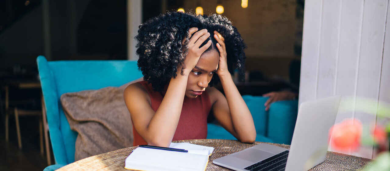 mulher em frente ao computador com cara de preocupada