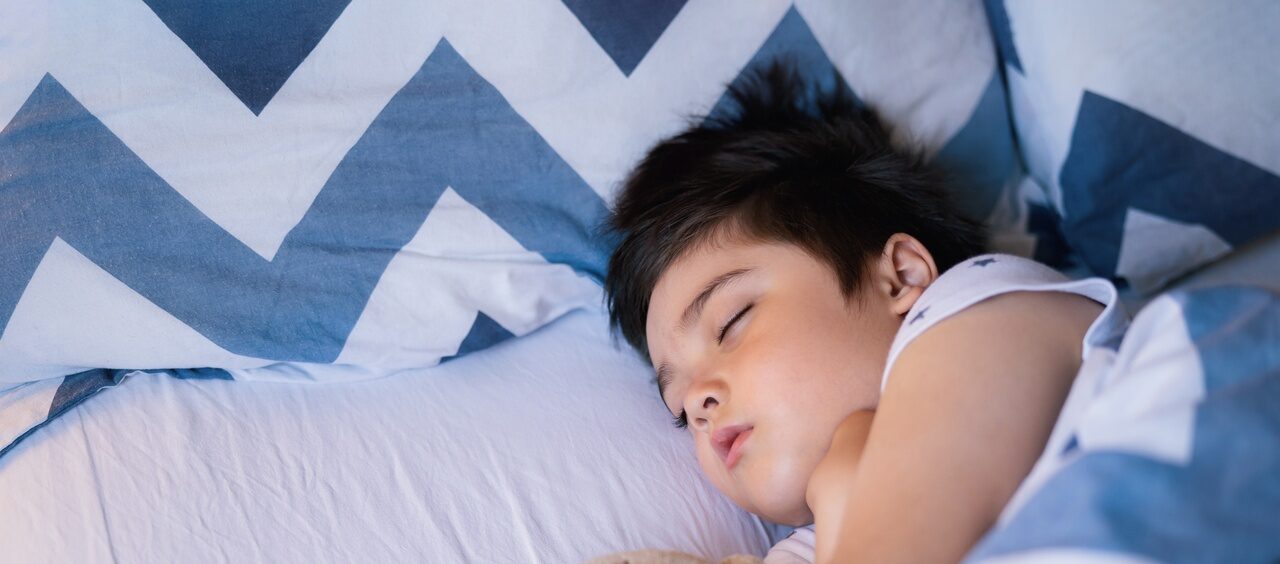 menino dormindo em sua cama abraçado bom uma pelúcia