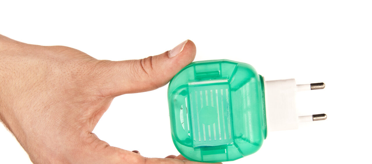 mão segurando um repelente de tomada