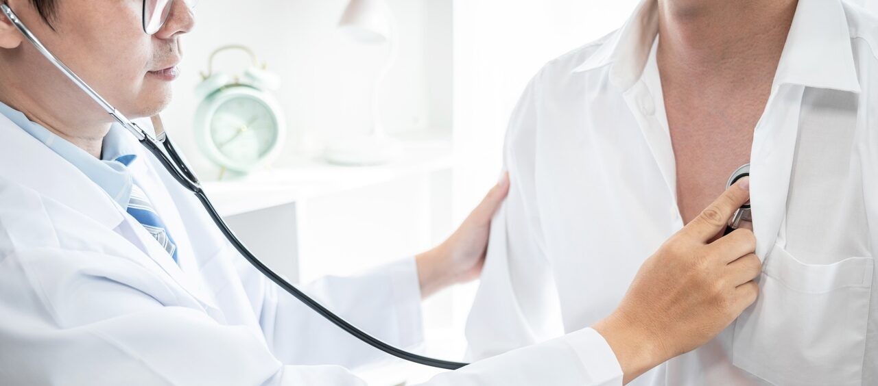 médico escutando batimentos cardíacos de um paciente com um estetoscópio