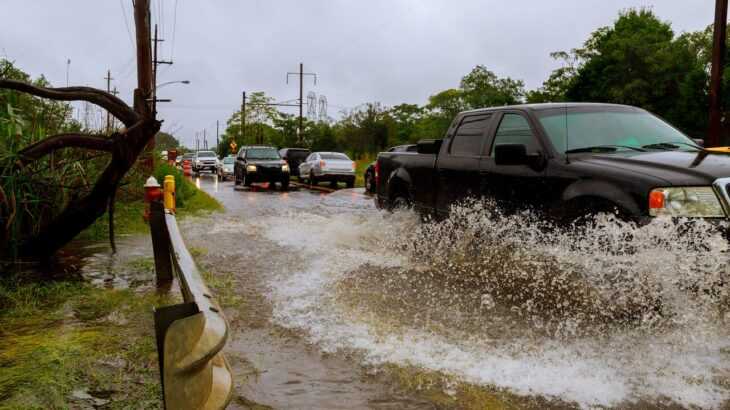 foto de carros passando por uma enchente