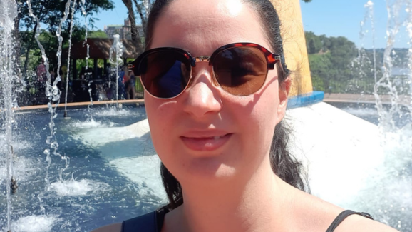 Selfie de Aline, cliente da Vitat, usando um óculos escuro e sorrindo. Ela começou a usar o aplicativo após um diagnóstico de ansiedade e insônia