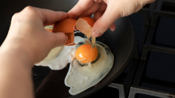 pessoa com gastrite quebrando um ovo em uma frigideira