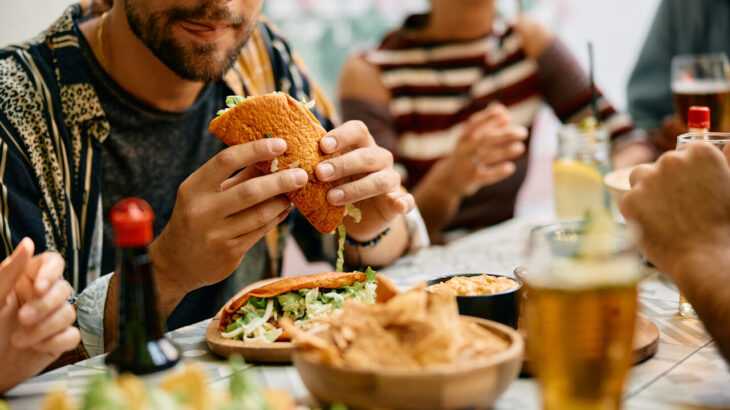 grupo de pessoas comendo e bebendo em um restaurante