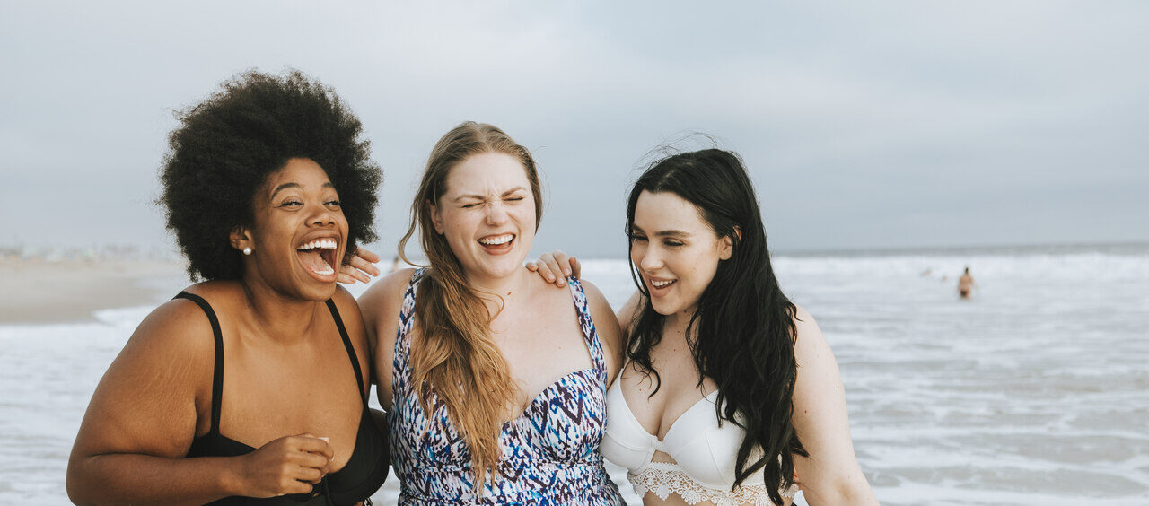 três mulheres felizes na praia